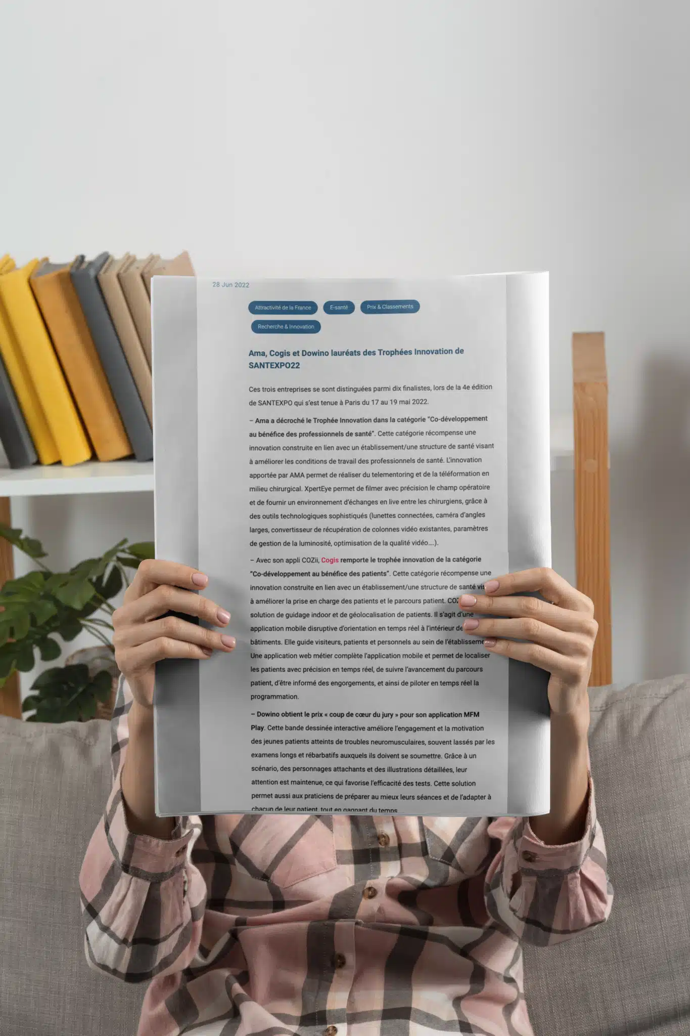 Mockup : une personne tenant un journal dans les mains avec l'article affiché dessus pour représenter l'application de géolocalisation