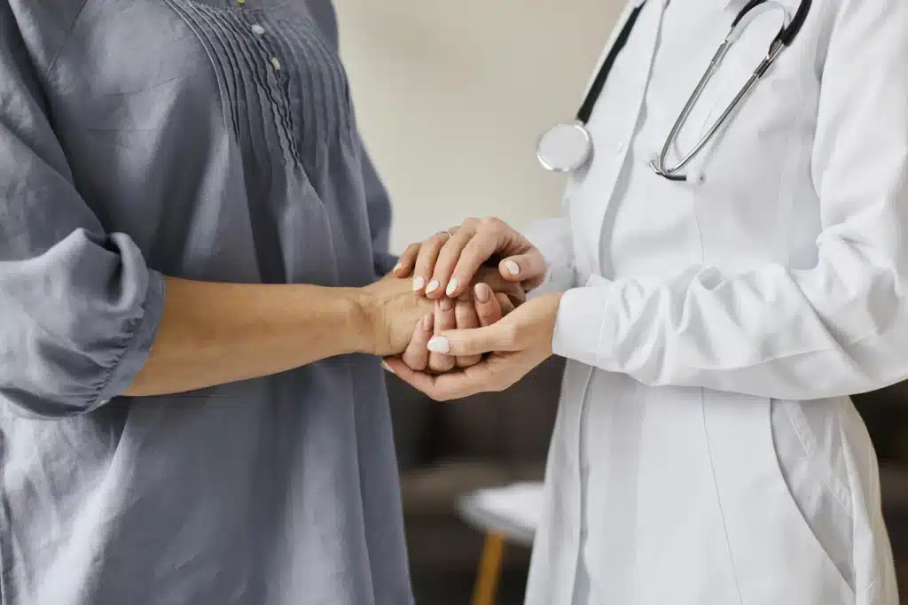 Photo d'une médecin tenant la main d'une patiente pour représenter l'appel malade intelligent